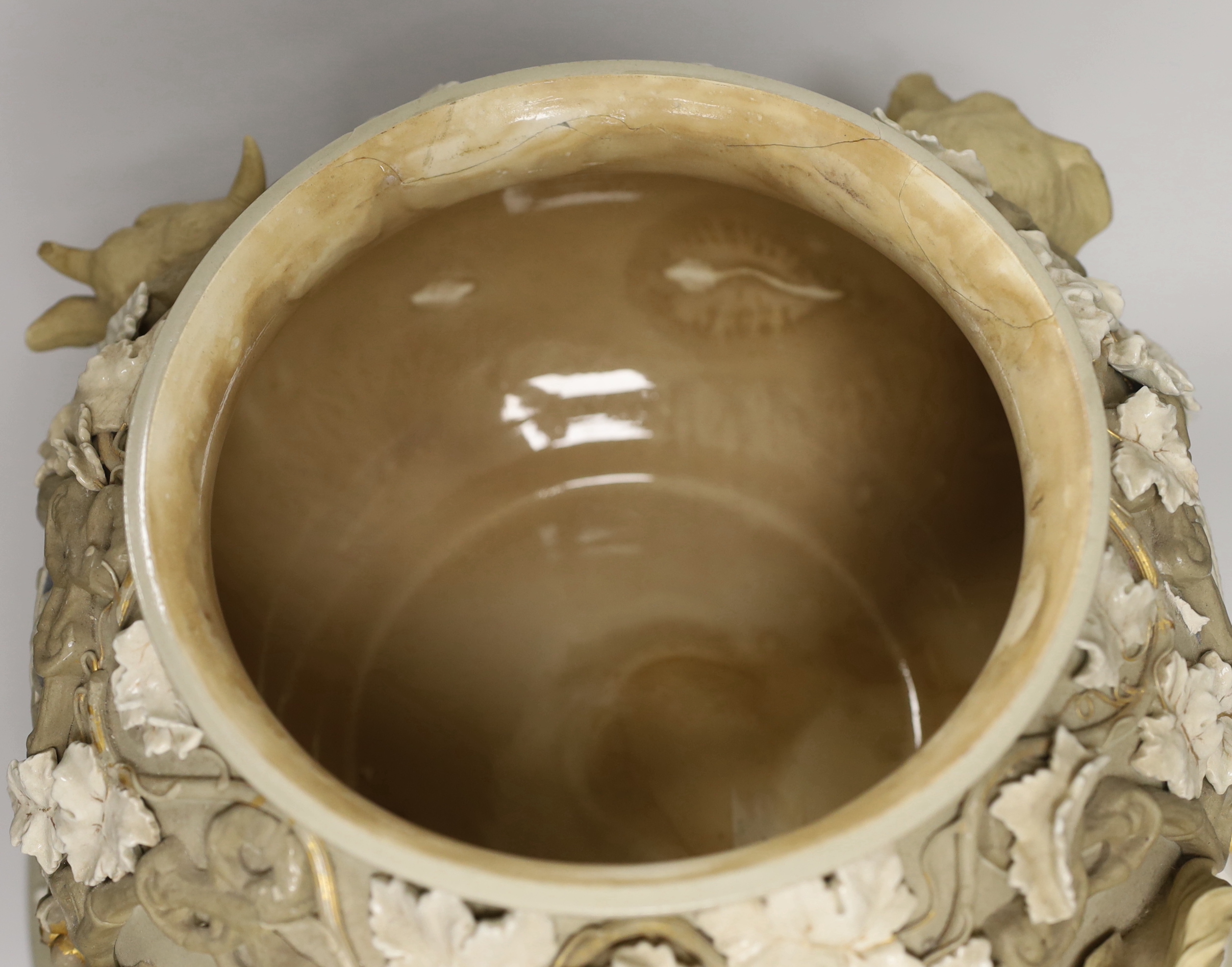 An impressive English cane ware and drab ware ‘agriculture’ soup tureen, cover and stand with cover, modelled with cattle, a dog and a horse’s head, amongst twining vines and crests, 38cm high